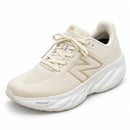 New Balance 1080 Off/Ouro — vista frontal em três quartos, ponta à esquerda
