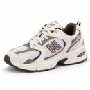 New Balance 530 Off/Café — vista frontal em três quartos, ponta à esquerda