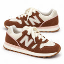 New Balance 574 Marrom — par em três quartos e direções opostas