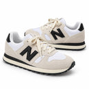 New Balance 574 Off/Preto — par em três quartos e direções opostas