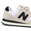 New Balance 574 Off/Preto — detalhe lateral do calcanhar adaptado