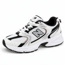 New Balance 530 Branco/Preto, vista frontal medial em três quartos com a ponta para a esquerda, fundo branco