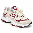 New Balance 9060 Off/Bordo, vista frontal lateral em três quartos com a ponta para a direita, fundo branco