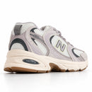 New Balance 530 Off/Lilás — vista traseira baixa em três quartos
