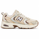 New Balance 530 Off/Dourado/Café, vista lateral com a ponta para a direita, fundo branco